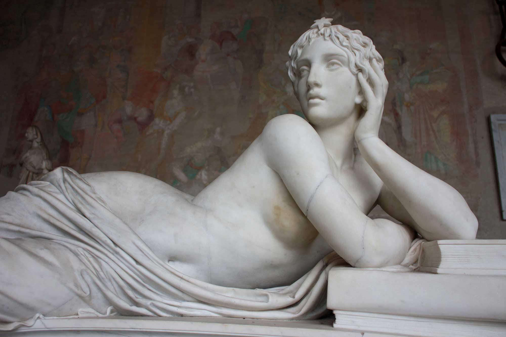 Links - Klassische weiße Marmorstatue einer liegenden weiblichen Figur mit Stern im Haar